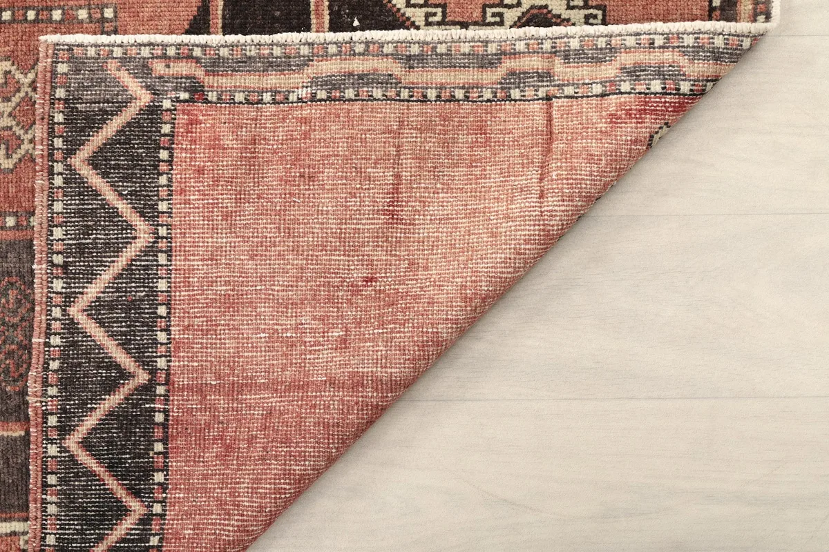 Underside view of the rug's corner, revealing the tightly woven cotton foundation.