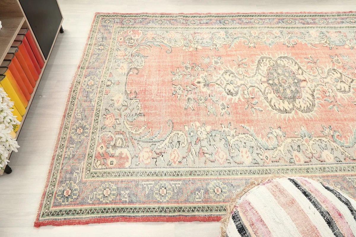 Side angle view of the rug, capturing the blend of rose, blue, and green colors