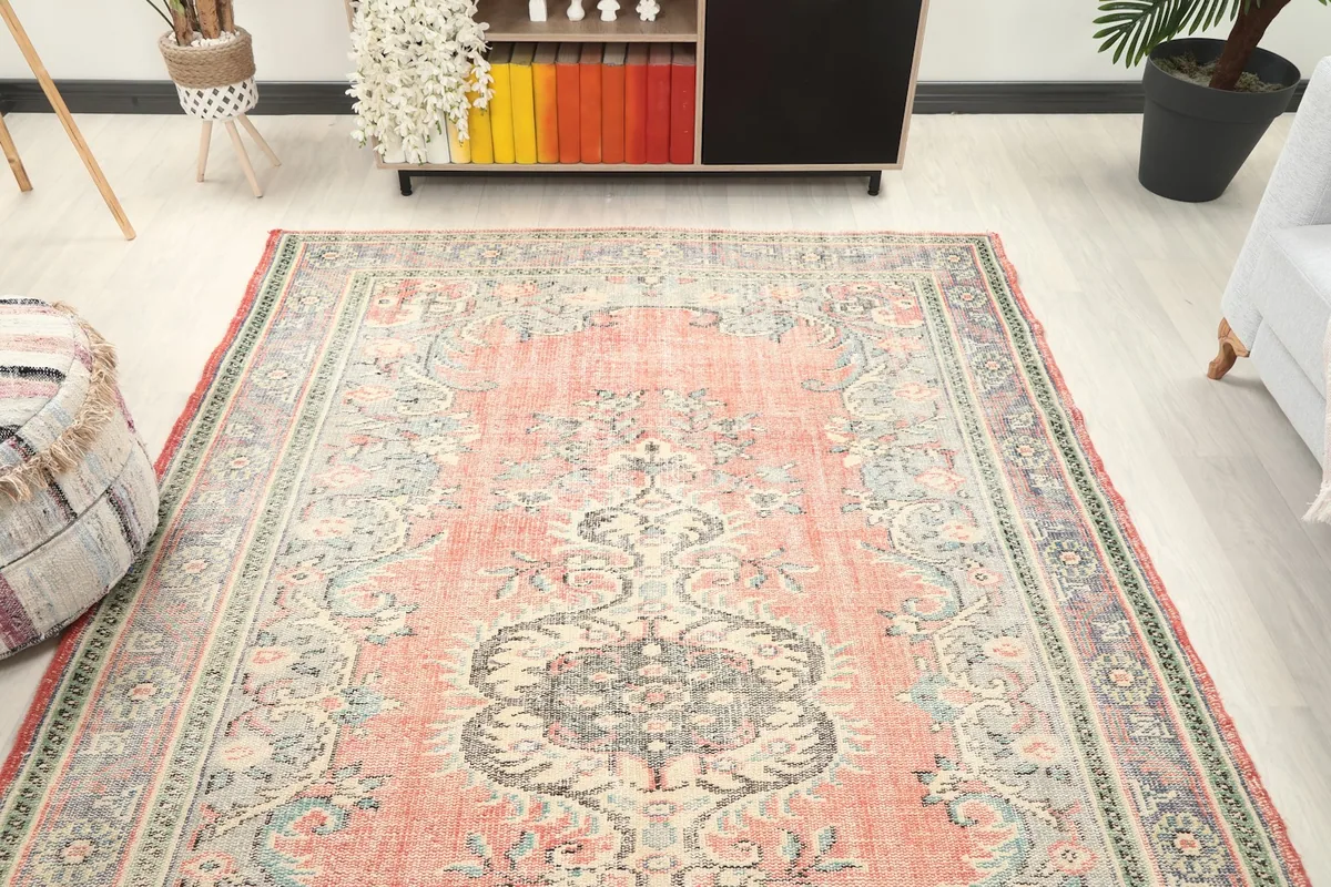 Full view of the rose Anatolian rug from a wider angle, showcasing its presence in the room