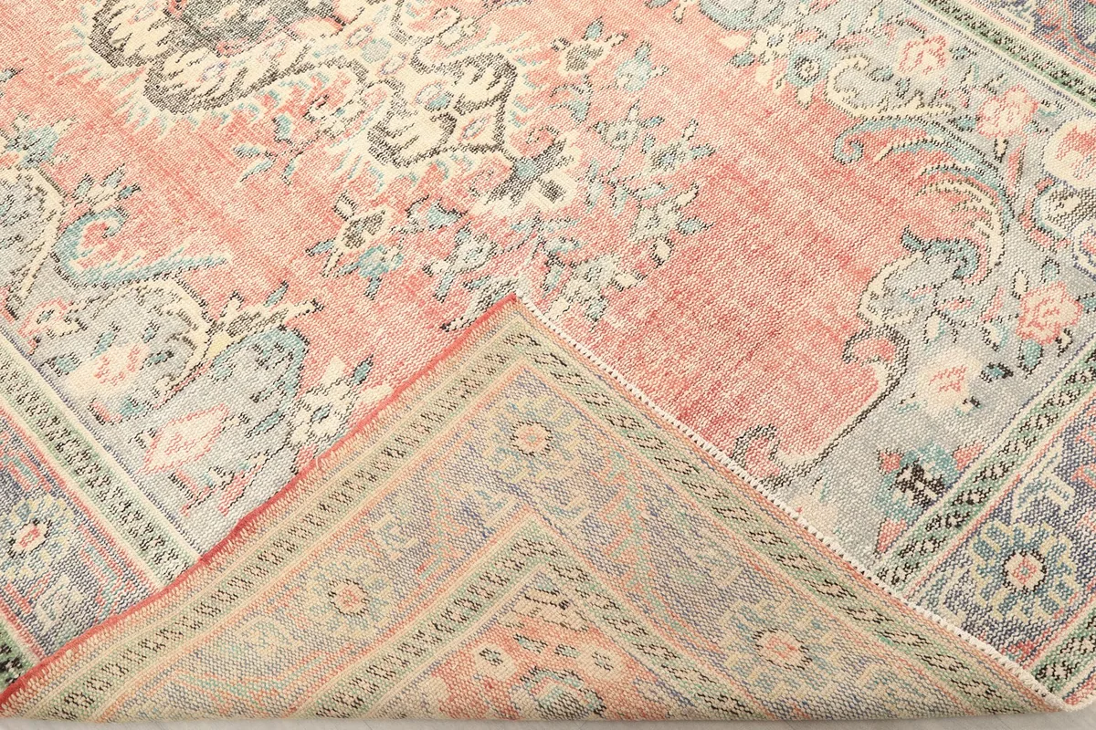 Folded corner of the rug revealing the back of the hand-knotted cotton foundation and pile depth