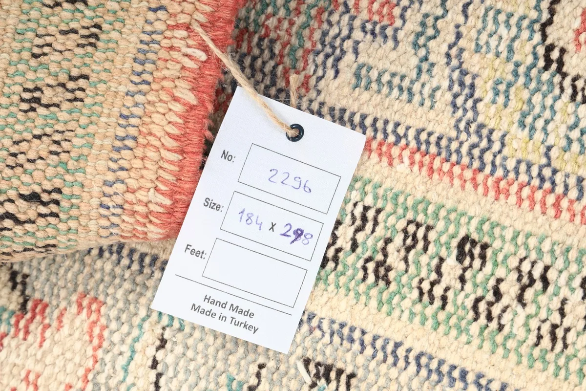 Close-up of the rug's back with a tag indicating its hand-made origin from Turkey