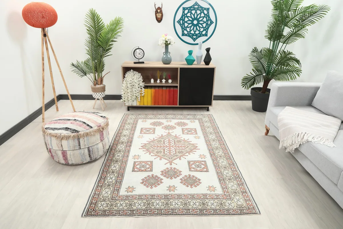 Ivory and rust geometric rug placed in a modern living room setting with a light-colored sofa.