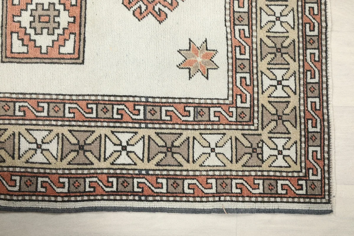Detailed view of the intricate geometric patterns within the border of the Anatolian rug.