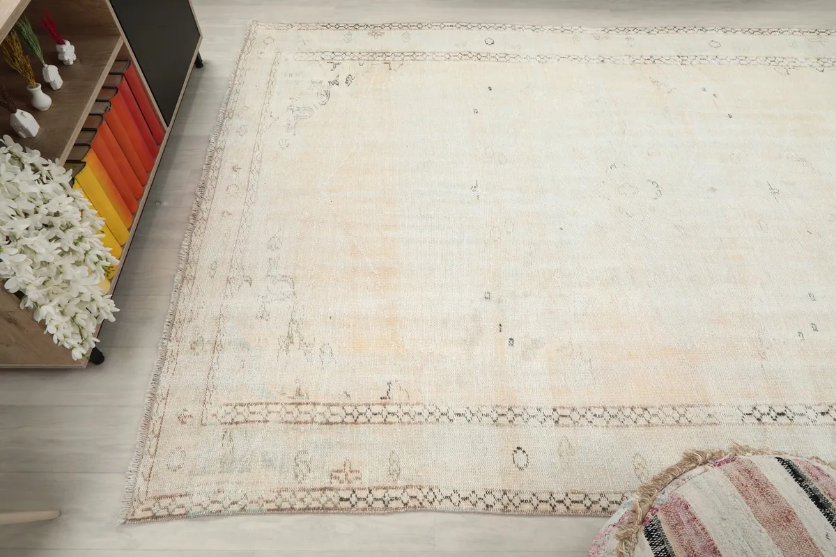 View from above, focusing on one end of the cream rug and its interaction with the room's decor