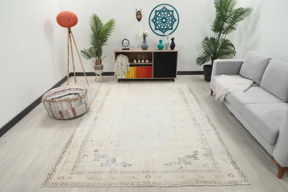 Cream vintage Anatolian rug displayed in a bright living room setting with a sofa and decor