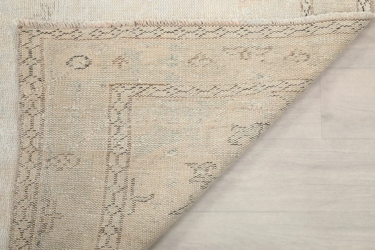 Close-up of a folded corner, showing the craftsmanship of the hand-knotted wool and foundation