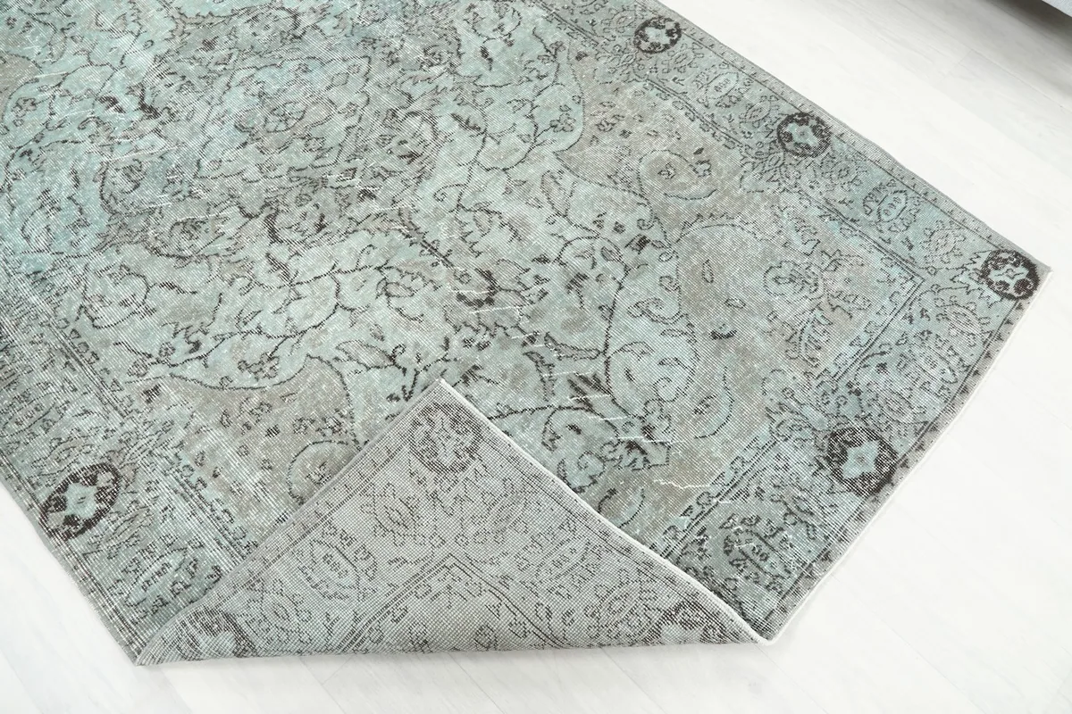 Folded corner of the rug, revealing the thickness of the hand-knotted wool pile and cotton foundation