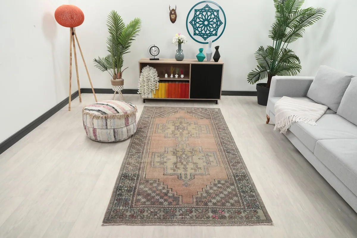 Vintage Anatolian rug displayed in a modern living room setting with a gray couch and light flooring