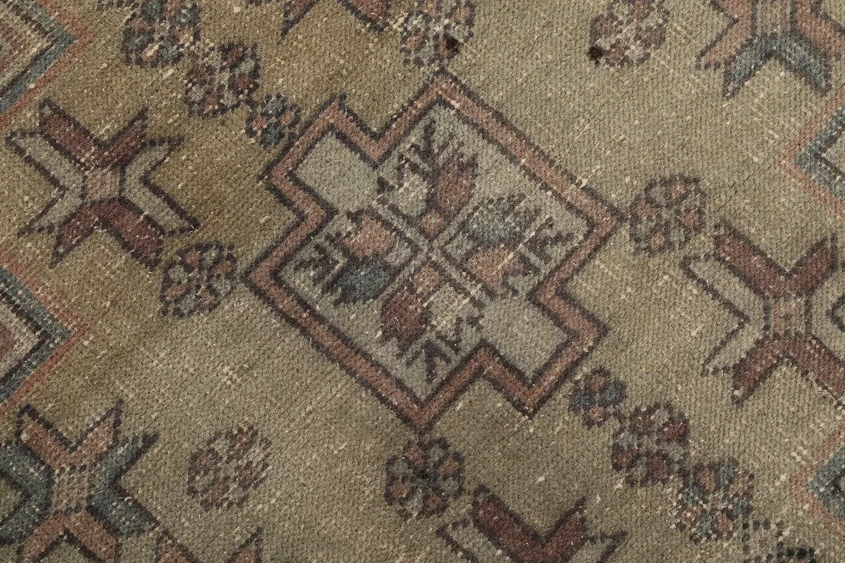 Macro shot of the wool pile, showing the texture and faded colors within the olive medallion