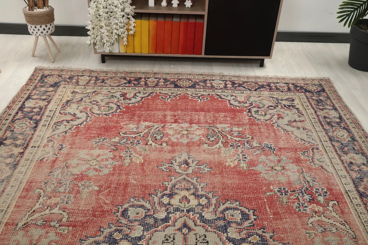 View across the length of the red vintage rug, highlighting its full pattern and distressed texture
