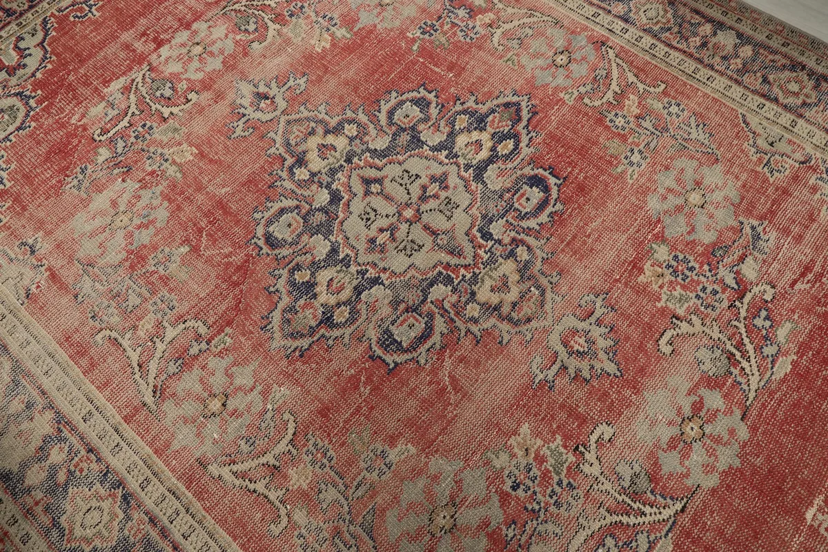 Overhead close-up of the central navy and beige medallion against the distressed red field