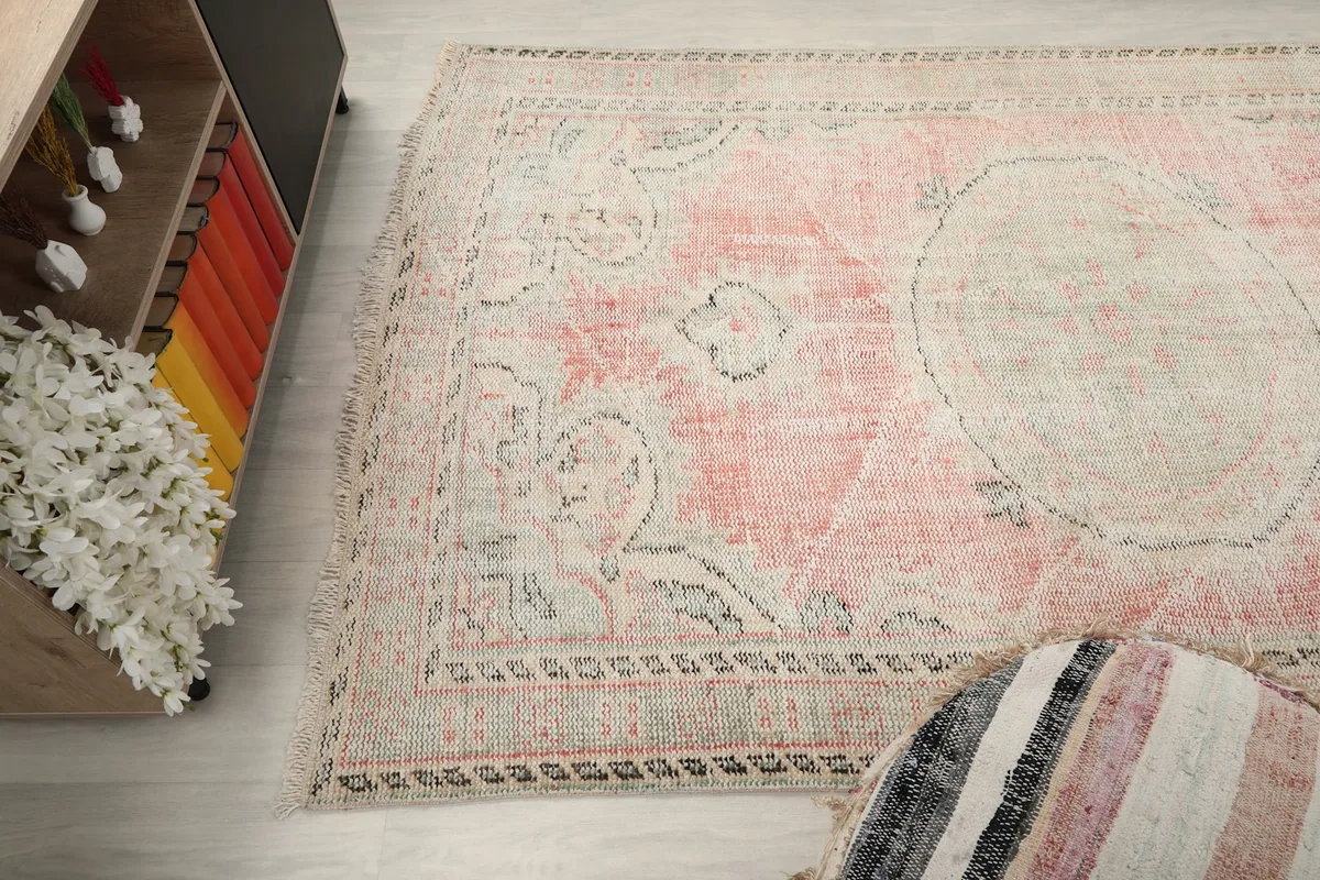 Close-up angle view of the rug's surface, capturing the faded rose and gray patterns