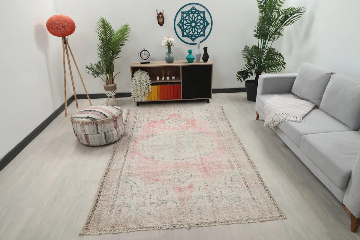 Vintage rose and gray medallion rug displayed in a living room setting with a sofa and decor