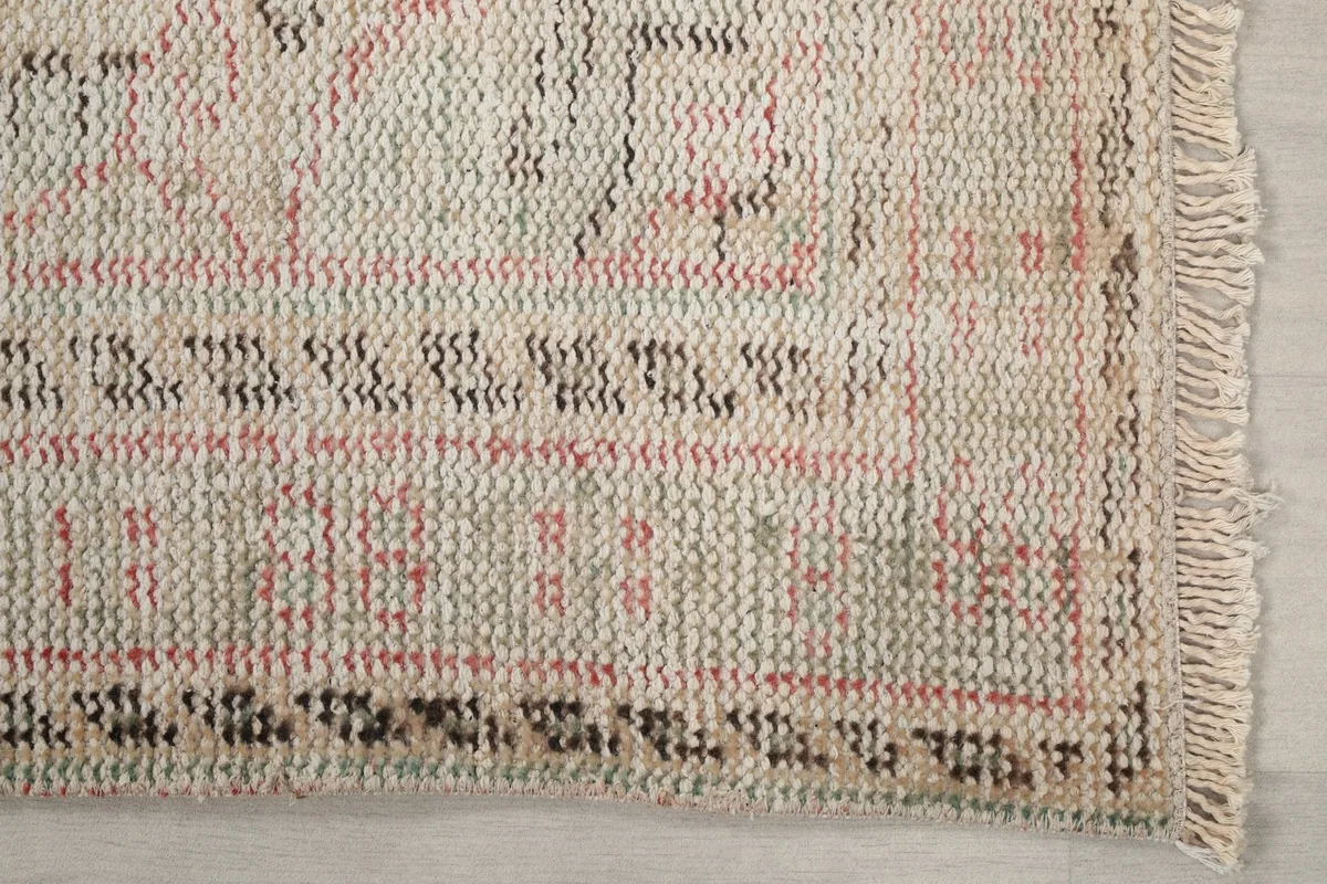 Detailed view of the rug's border pattern and fringe showing the hand-knotted texture