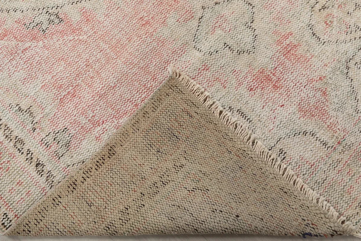Folded corner of the rug, displaying the low pile and the construction of the vintage piece