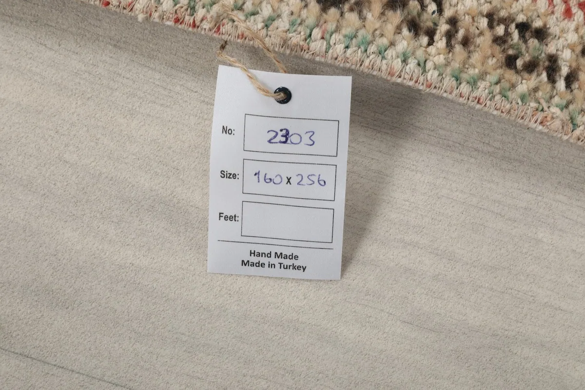 Tag with rug details: number, size in centimeters (160x256), and 'Hand Made Made in Turkey'