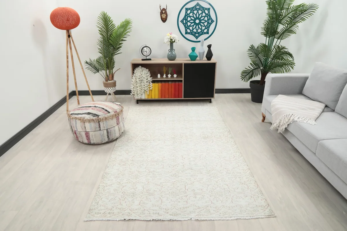 Vintage cream and rose Anatolian rug displayed in a bright living room setting