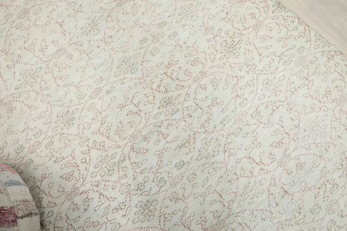 Overhead shot of the rug's center, revealing the intricate, faded floral and geometric design