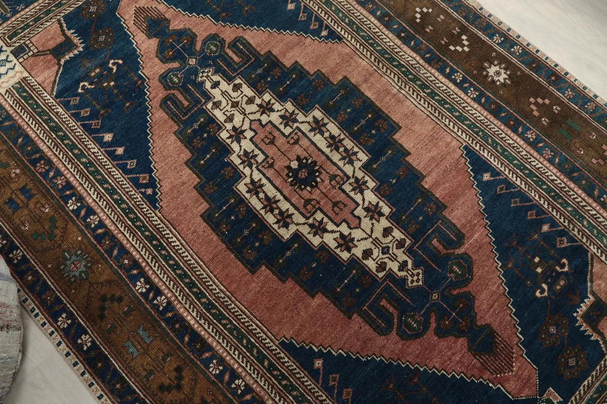 Overhead detail of the central rose field and navy geometric patterns within the medallion.