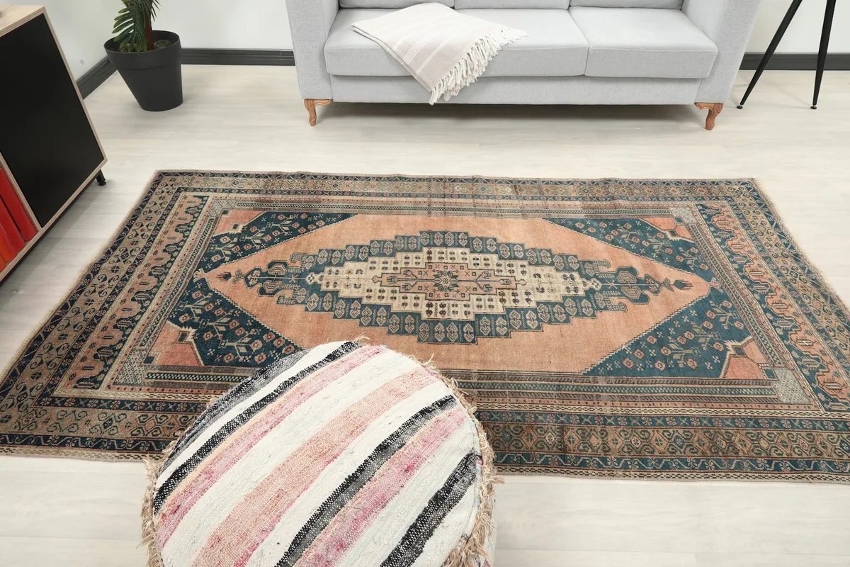 Overhead view of the vintage rug in a room, with a sofa and pouf