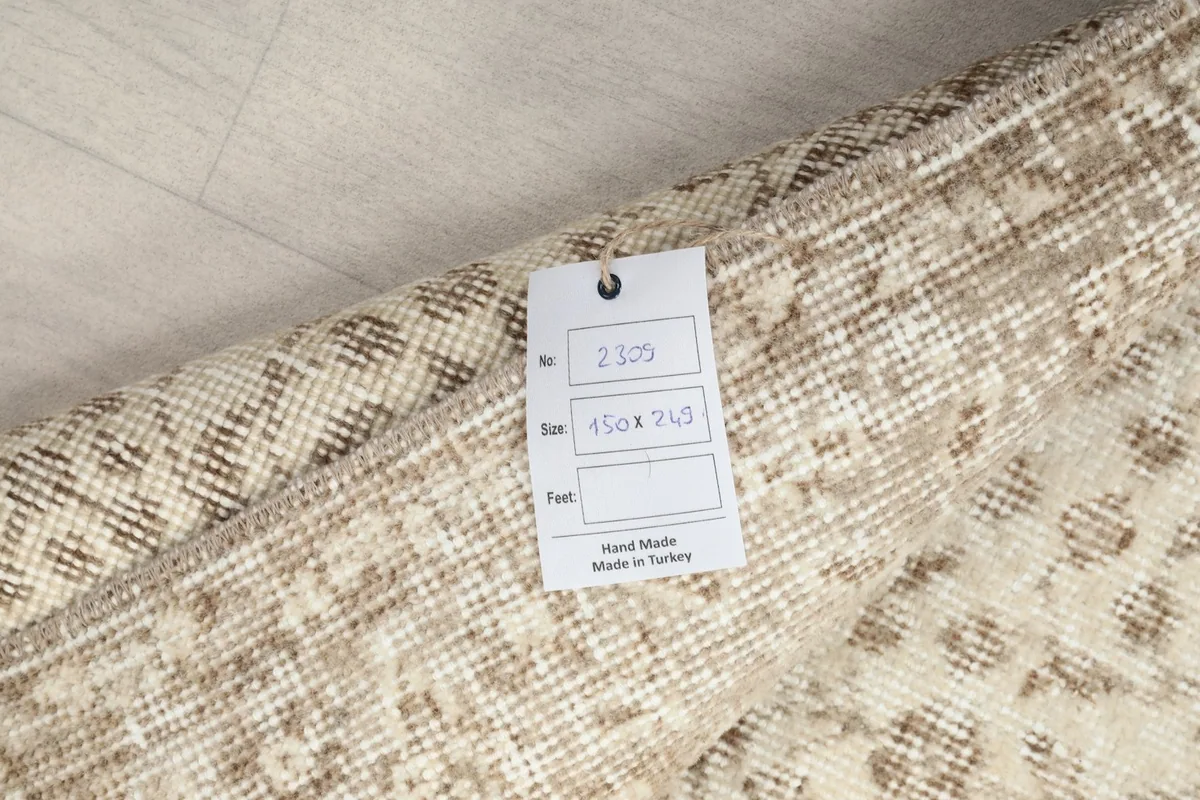 Close-up of the rug's label with size information and 'Hand Made in Turkey' on the reverse side