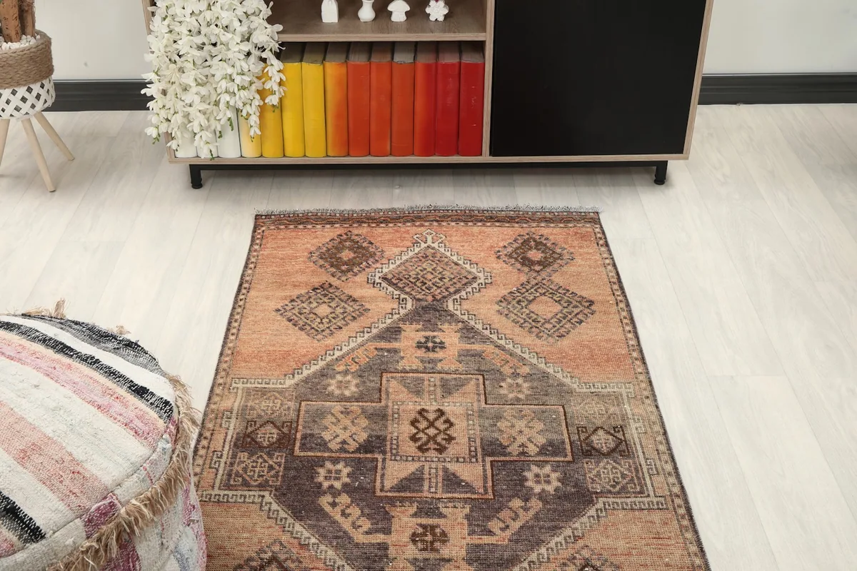 View of one end of the runner rug in a room, showing its placement near a low cabinet with colorful books.