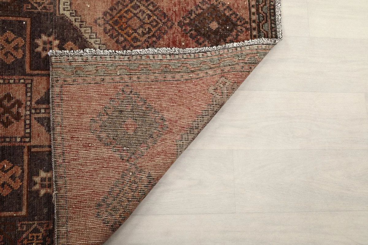 Underside view of the hand-knotted rug, revealing the cotton foundation and the back of the wool pile.