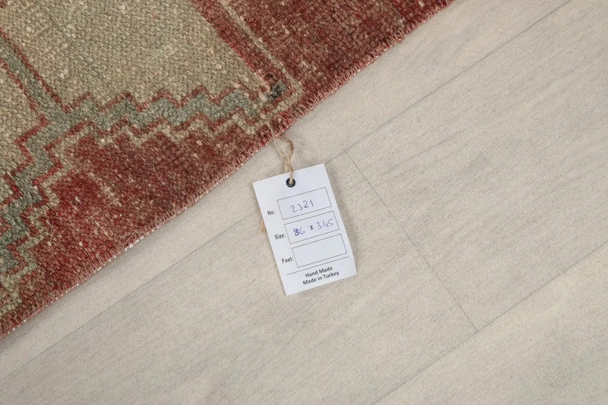 Small tag attached to the rug, indicating its origin and hand-knotted craftsmanship