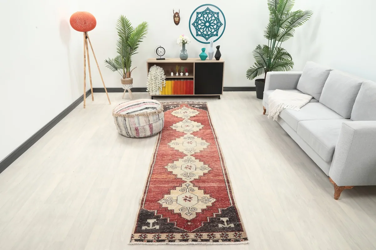 Long view of the runner rug in a modern living space with a gray sofa and plants.