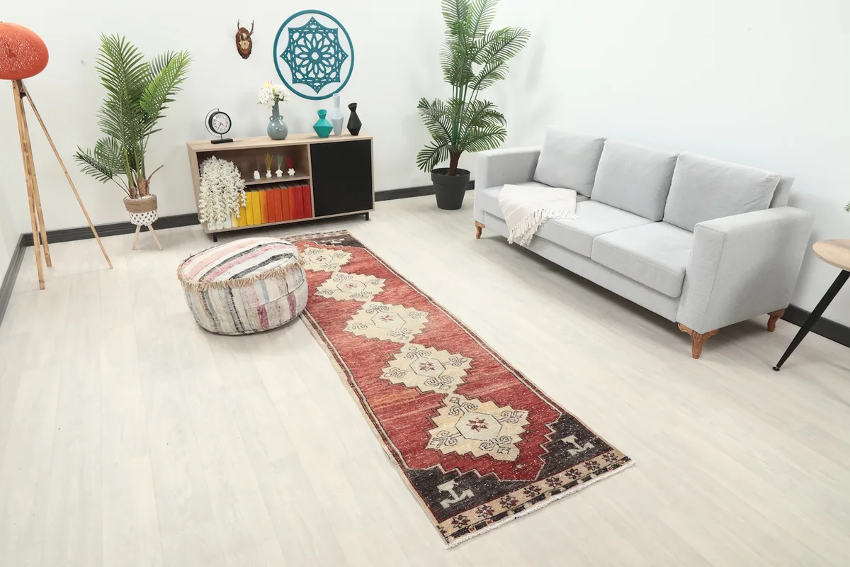 Angled view of the runner rug in a room, showing its length next to a gray sofa and ottoman.
