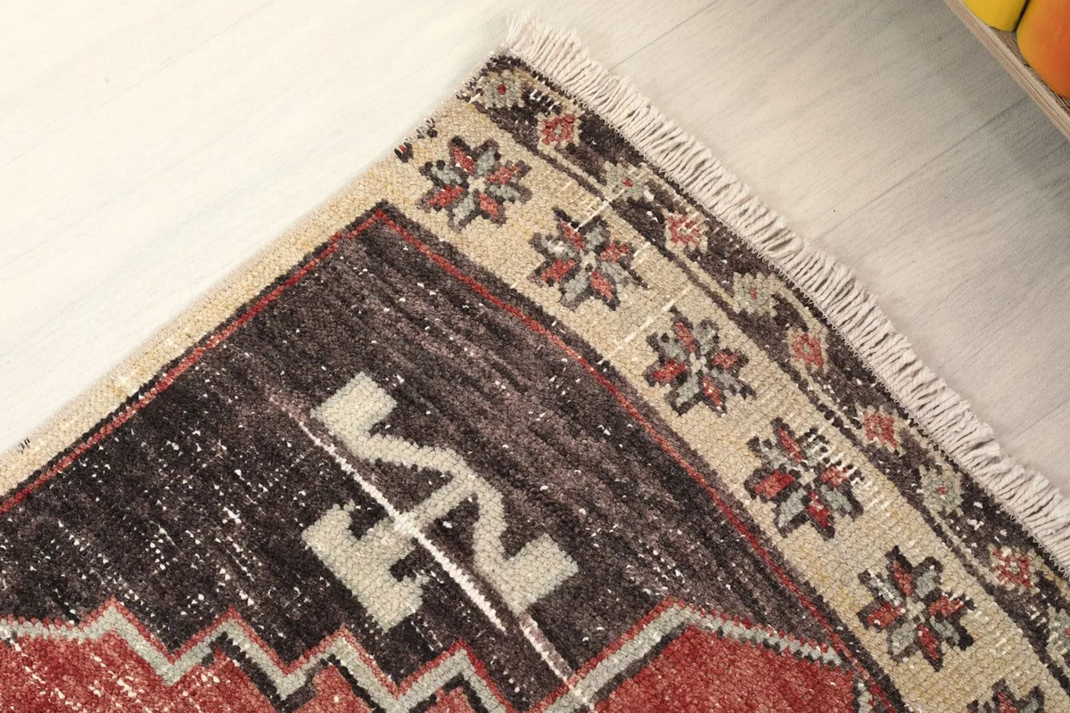 Close-up of the rug's upper right corner, showing the border design and fringe.