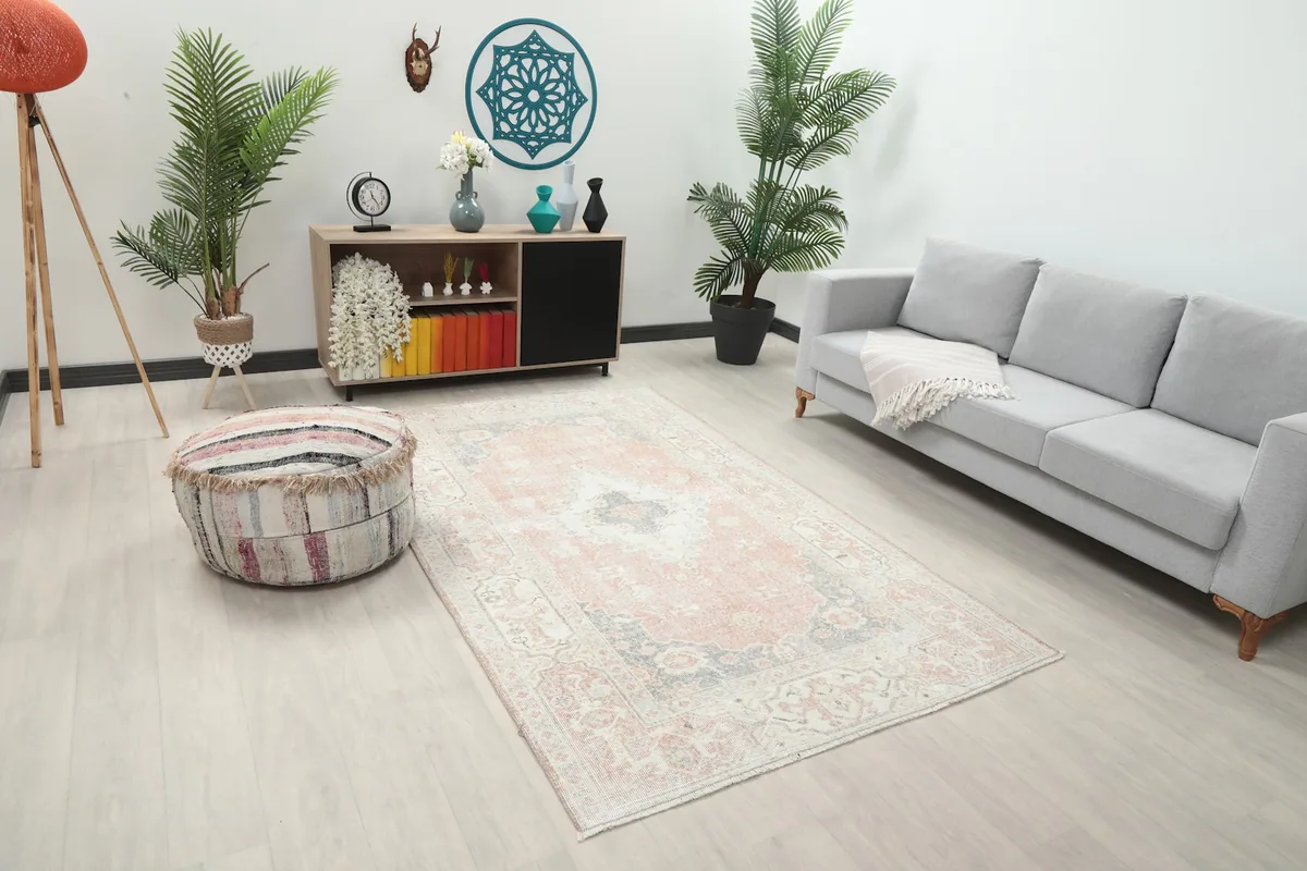 Angle view of the rose and gray medallion rug in a living room, showing its placement with furniture.