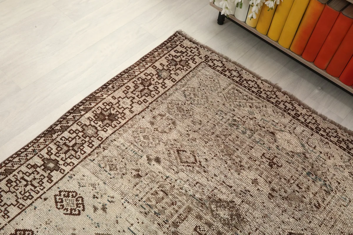 Corner view of the rug from above, emphasizing the detailed border and faded central design.
