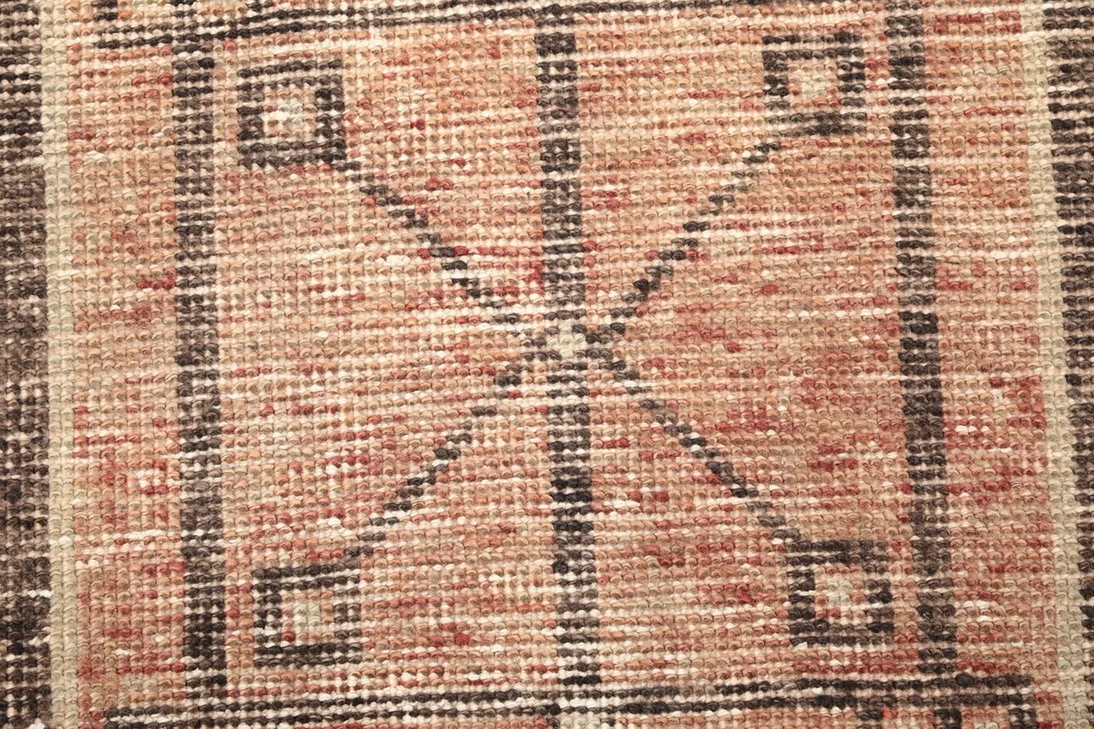 Macro shot of the rug's low wool pile, revealing the hand-knotted texture and fiber detail.