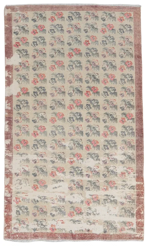 Full overhead view of the beige floral vintage Anatolian rug on a white background.