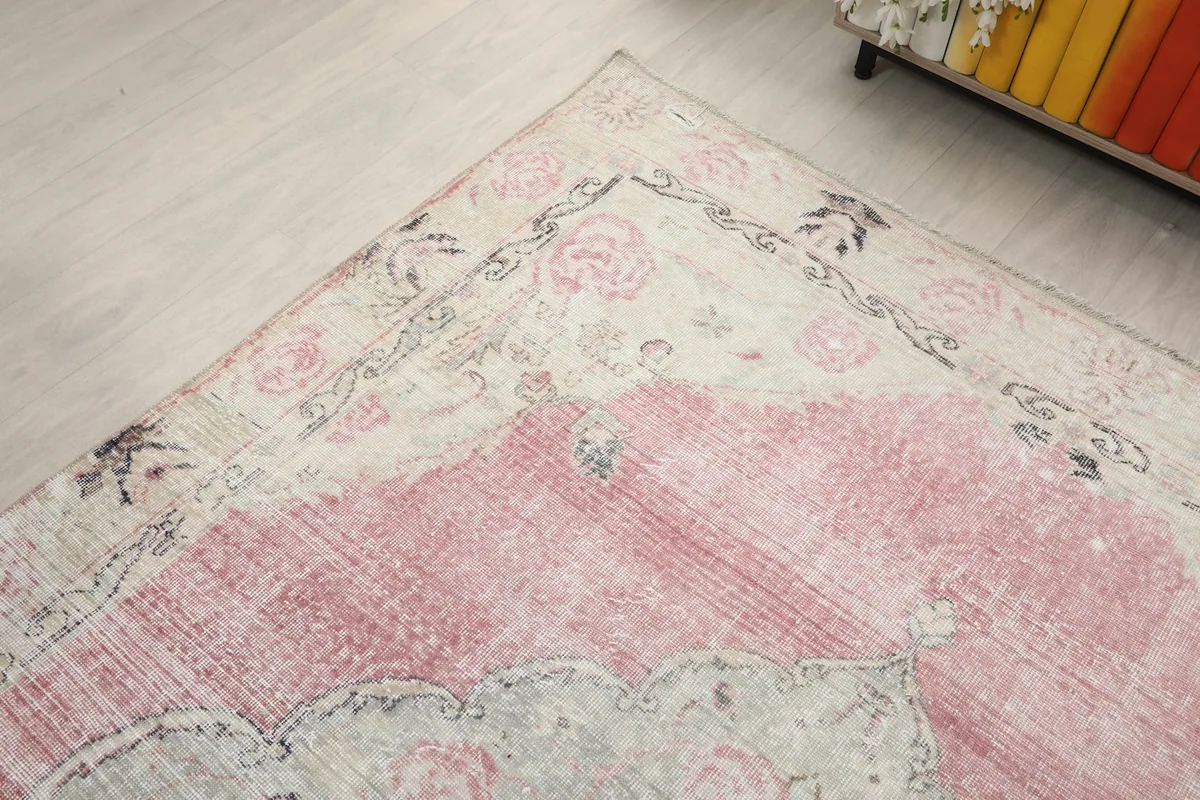 Angled view focusing on a corner of the rug, showing the border design and color variation.