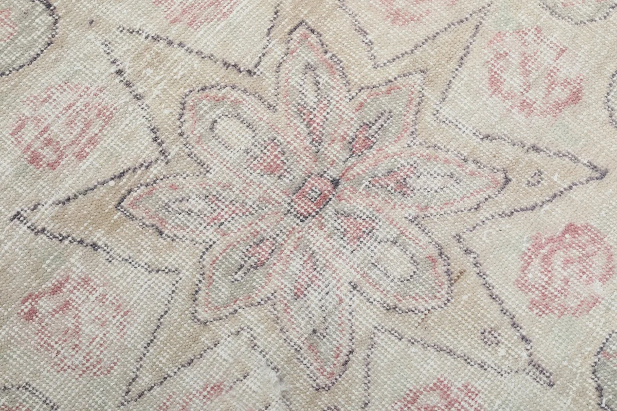 Macro detail showing the hand-knotted wool pile and a floral design element.