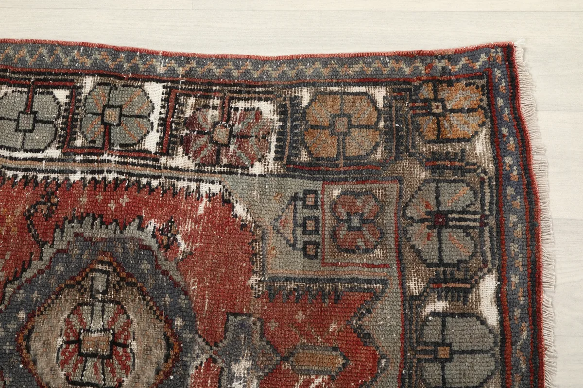 Close-up detail of the Faded Red Tribal Geometric Rug's upper right corner, highlighting geometric motifs.