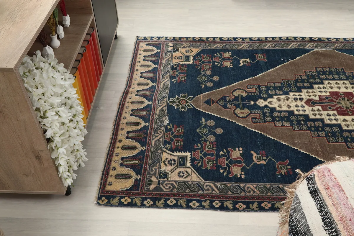 Angled shot showing the rug's width and detailed patterns near a cabinet