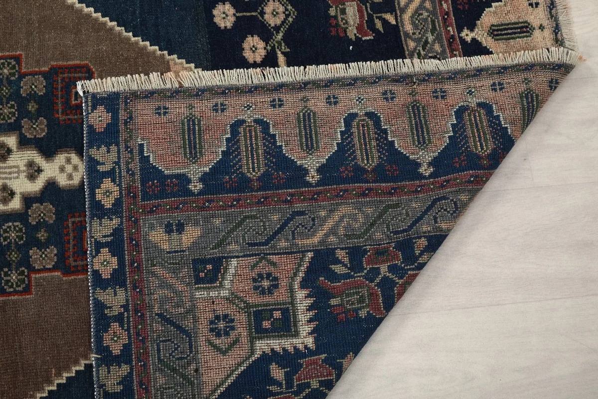 Close-up of the rug's fringe and a folded corner, showing the hand-knotted detail