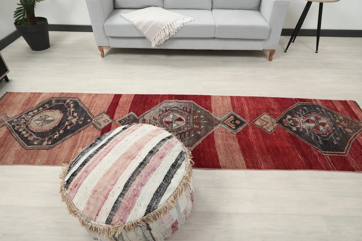 Full view of the runner rug in a room, showing its length from a higher perspective, with a sofa and pouf.