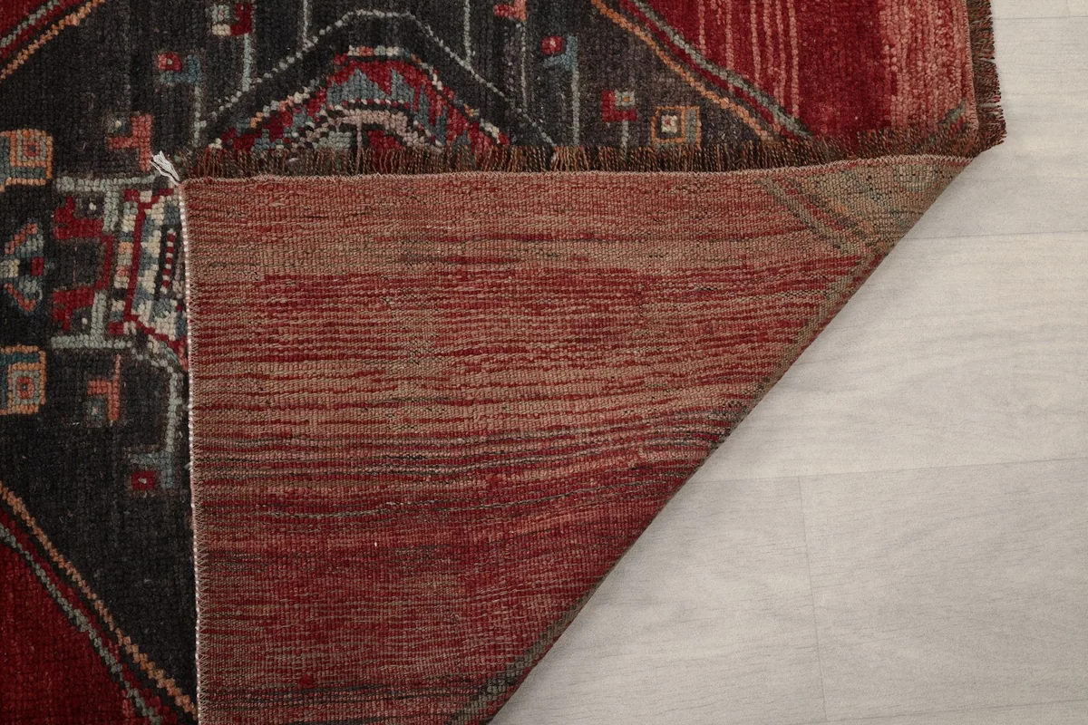 Close-up of the back of the rug, revealing the tightly woven cotton foundation and wool fibers.