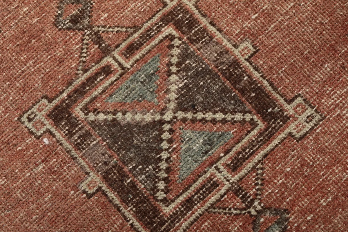 Texture and low pile of the hand-knotted wool rug, showing subtle wear
