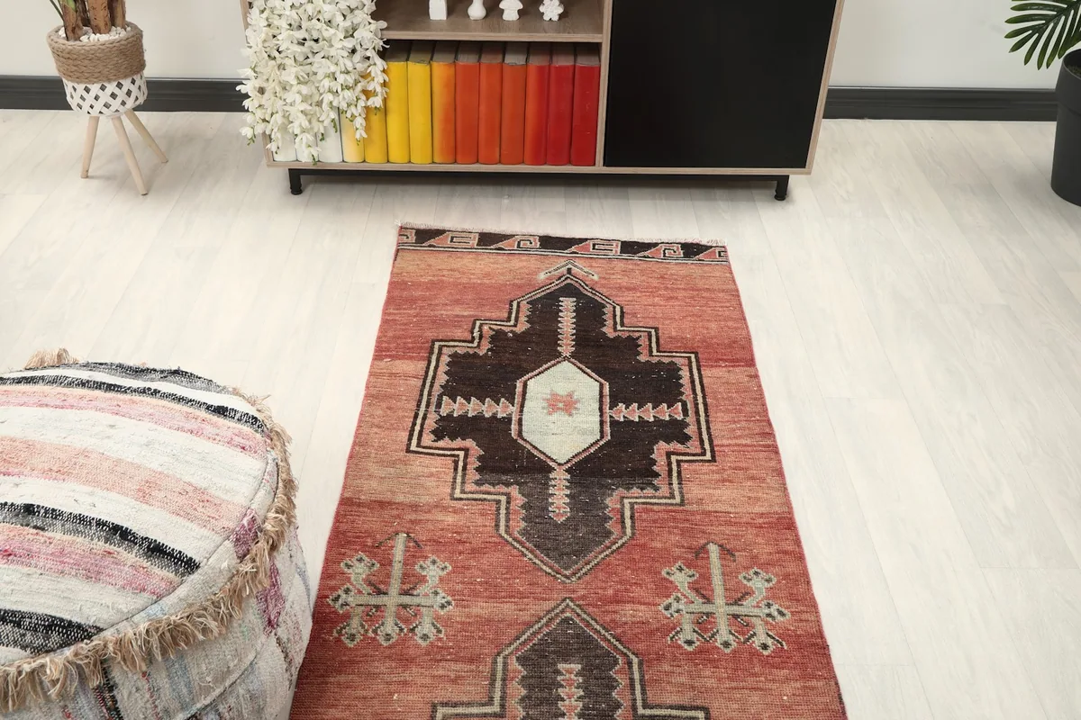 View looking down the length of the rust runner rug in a hallway, showing repeat patterns