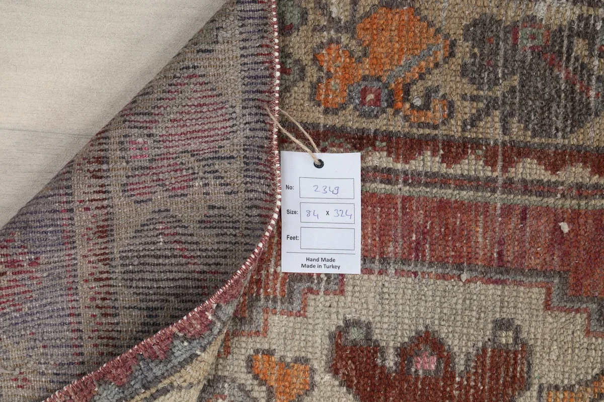 Close-up of the rug's back with a tag, confirming the hand-knotted origin and material.