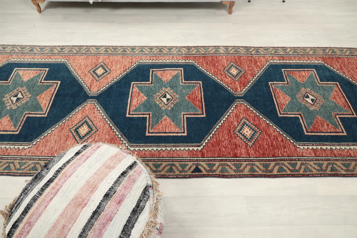 View of the rug from another angle, showing the long runner with an ottoman in the foreground