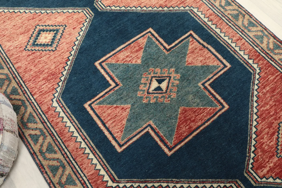 Close-up of a navy geometric star motif with green and ivory accents on the runner rug