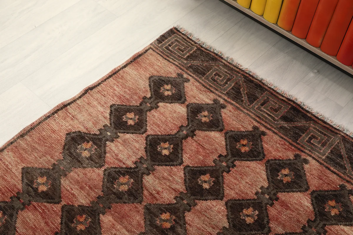 Detail of the runner's corner, showcasing the geometric border and diamond pattern