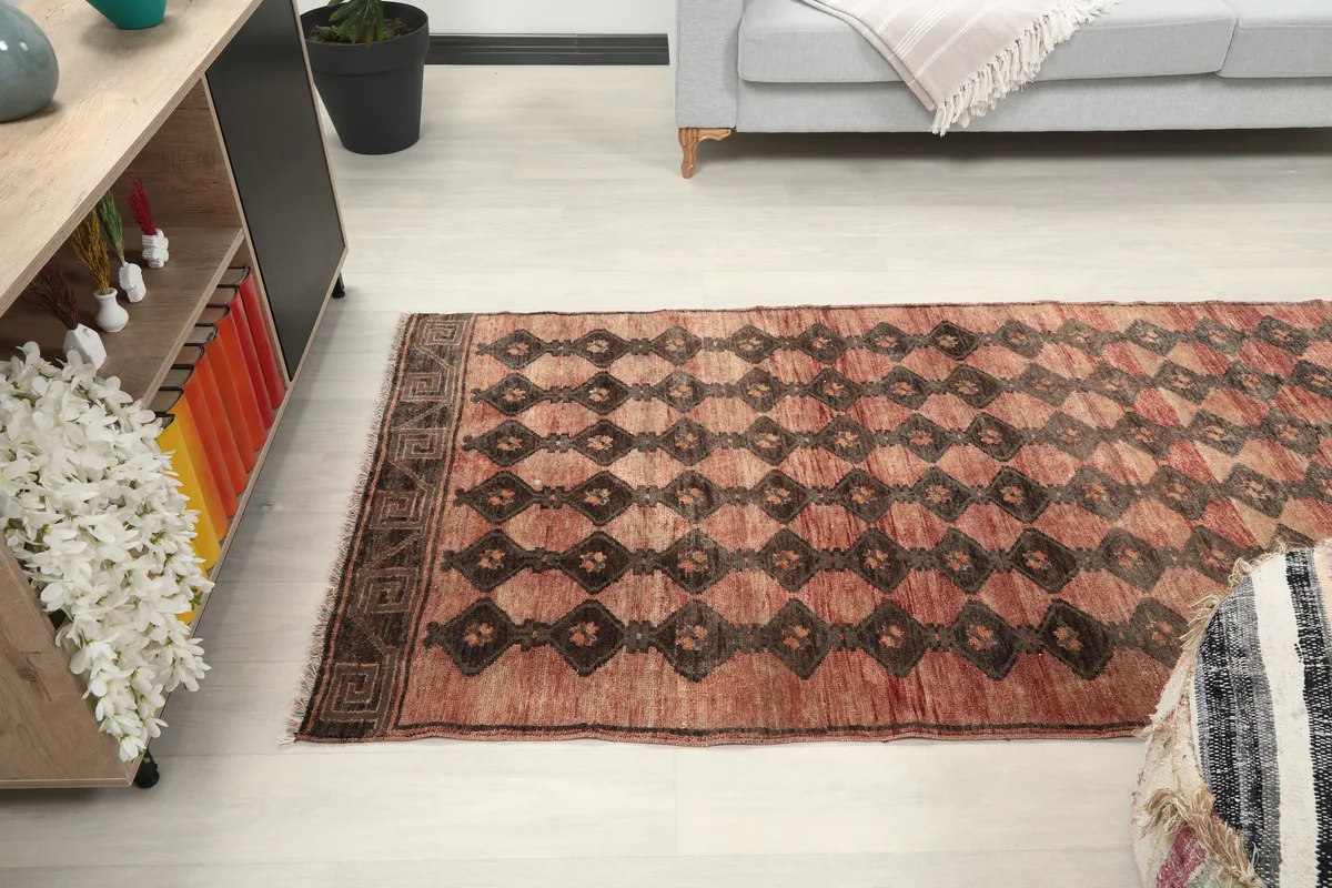 Rust Geometric Tribal Runner in a room, offering a perspective of its placement next to furniture