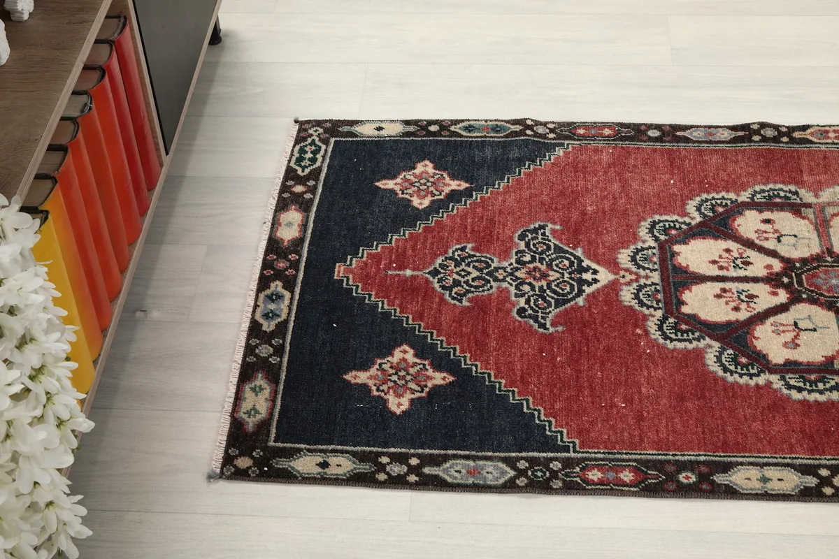 Side angle view of the rug on the floor, showcasing its rectangular shape and design elements.